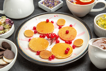 front view yummy pancakes with berries and flowers on a grey background fruit dessert sweet