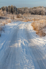 Narrow winter country road on a clear sunny day.