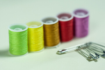 Multicolored coils of thread on a green background.