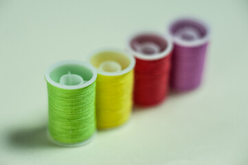 Multicolored coils of thread on a green background.