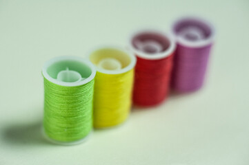 Multicolored coils of thread on a green background.