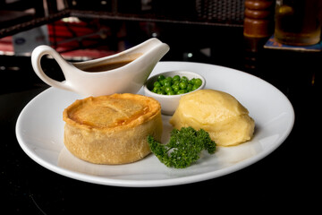 British pie served with potato mach, peas and gravy. Pub food