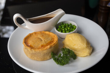 British pie served with potato mach, peas and gravy. 
Pub food