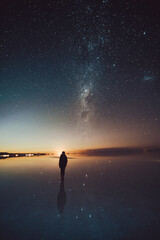 person on the lake under stars and Milky Way 