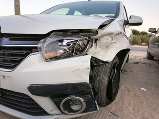 Fototapeta na wymiar front right side headlight bumper and tire are badly damaged by an accident of a brand new silver car
