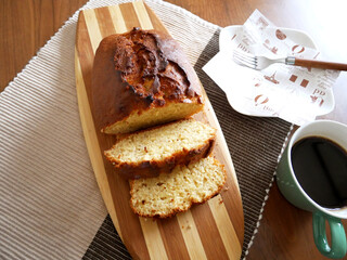 カッティンボードに置かれたパウンドケーキとコーヒー