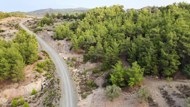 gravel road through nature reserver on greek island from above