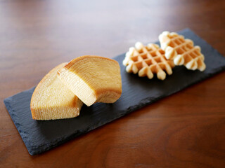 スレートプレートに乗せられたバウムクーヘンとワッフル