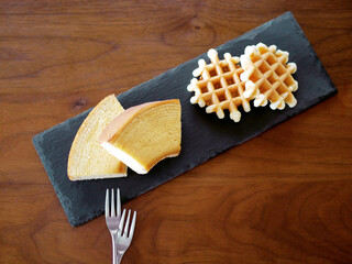 スレートプレートに乗せられたバウムクーヘンとワッフル