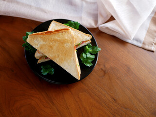 テーブルの上に置かれたベーコンチーズサンドイッチ