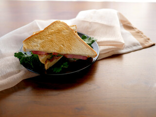 テーブルの上に置かれたベーコンチーズサンドイッチ