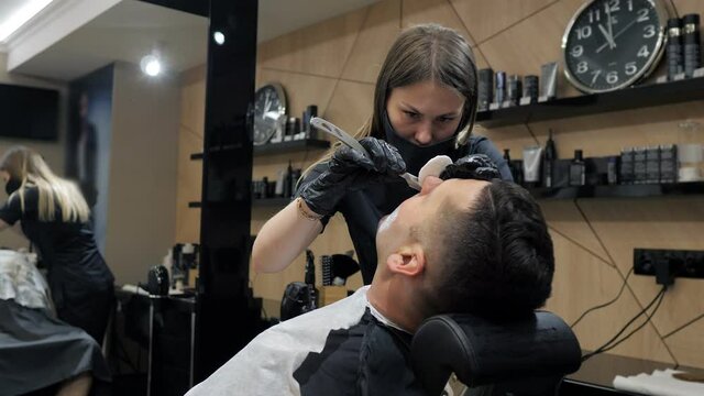 Close up view of young man getting groomed by hairdresser at barbershop