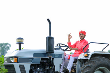 Indian farmer working with tractor at field