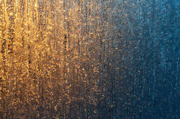 Frosty patterns on the window at dawn. Frosty window texture. Abstract background.