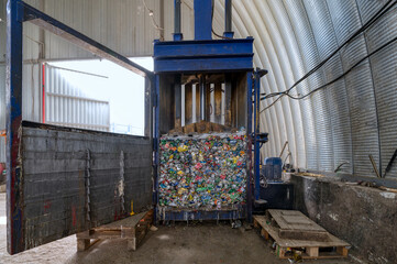 Fototapeta na wymiar Household waste sorting and recycling plant. Vertical press for squeezing metal cans