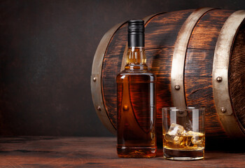 Scotch whiskey bottle, glass and old barrel