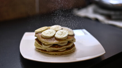 pancakes breakfast with bananas on white dish