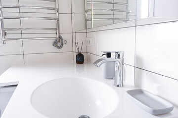 Modern bathroom at home. White stone table in bathroom and new mixer