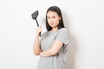 Asian woman holding ladle ready for cooking isolated on white background.