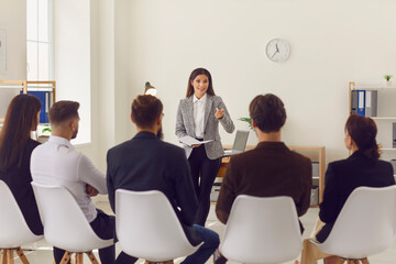 Business woman speaker making presentation or training for group of office workers