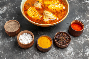 Spices set and homemade chicken dish on dark background