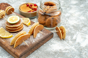 Buttermilk pancakes with lemons on cutting board and cookies on blue background stock image