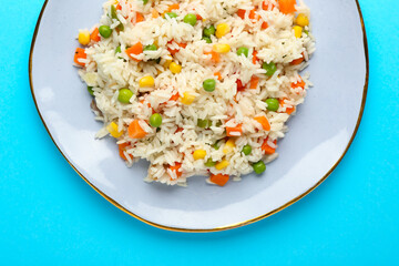 Plate with tasty pilaf on color background