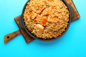 Bowl with tasty pilaf on color background