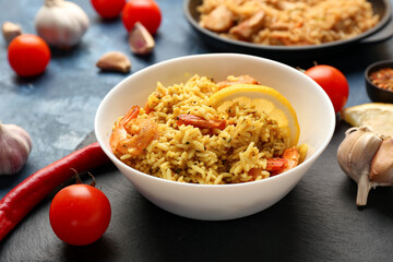 Plate with tasty pilaf on table