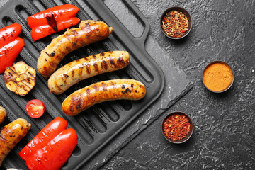 Grill pan with delicious grilled sausages, vegetables and spices