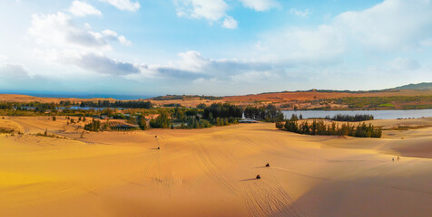 Aerial view of Bau Trang lake (raw of automobiles with blue sky in desert, beautiful landscape of white sand dunes), the popular tourist attraction place in Mui Ne, Vietnam.