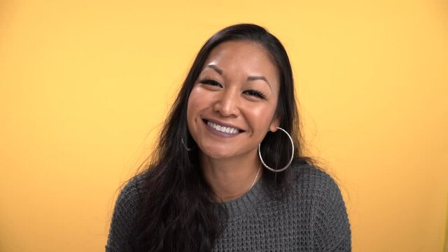 Excited woman knods her head yes in slow motion big smile big earrings