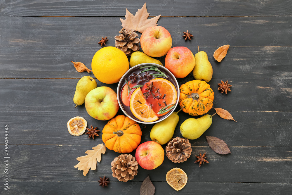 Wall mural Autumn composition with bowl of hot mulled wine on dark wooden background