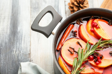 Saucepan with hot mulled wine on table, closeup