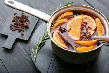 Saucepan with hot mulled wine on table