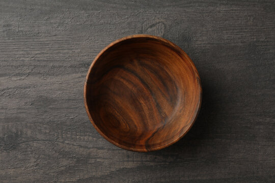 Empty wooden bowl on gray table, top view