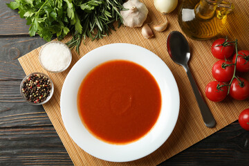 Concept of tasty dinner with tomato soup on wooden background