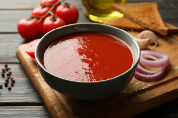 Concept of tasty dinner with tomato soup on wooden background