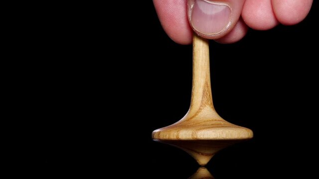 Close up shot of a wooden spinning top moving.