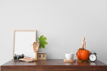 Autumn composition with wooden hand and mannequin on table in room