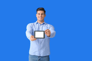 Young man with e-reader on color background