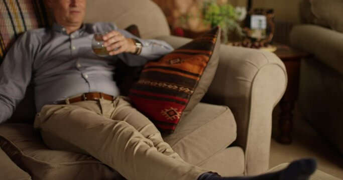 4k, Mature man relaxing on the sofa at home with a glass of whiskey