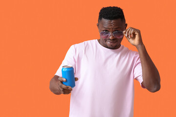 Handsome African-American man with soda on color background