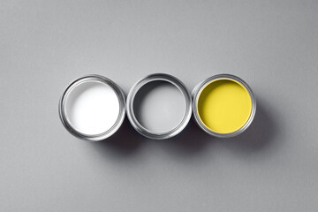 Open paint cans on grey background. Appartment renovation, repair, building, design concept....