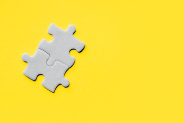 Closeup of jigsaw puzzle piece. Demonstrating trendy Color of Year 2021. Illuminating Yellow and Ultimate Gray. Duotone. Puzzle pieces on yellow background. idea, sign, symbol, concept of connecting