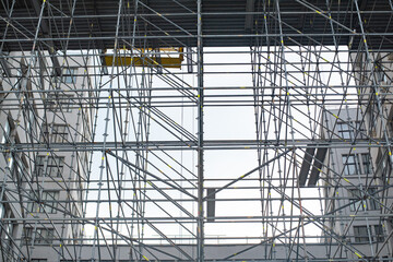 Obraz premium Extensive scaffolding providing platforms for work in progress on a tall building under construction with scaffolds.