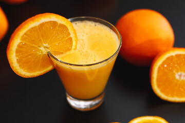 Glass of orange juice and oranges