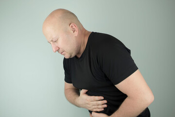 man holds his hands to his stomach, stomach upset, diseases.