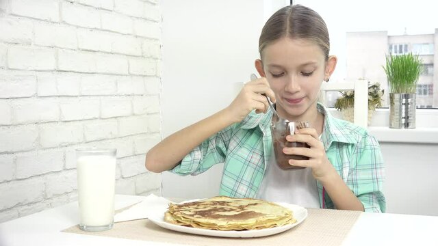Child Preparing Pancakes at Breakfast, Kid Eating Chocolate in Kitchen, Girl Prepares Griddle-Cake at Home