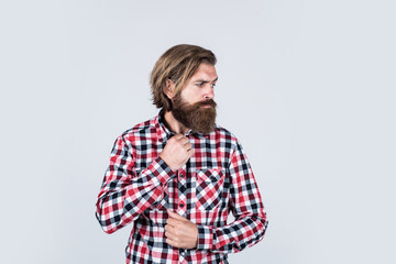Fototapeta premium handsome confident man has perfect hairstyle. bearded man in checkered shirt. male beauty concept. Portrait of bearded hipster. guy with long lush beard and mustache on face
